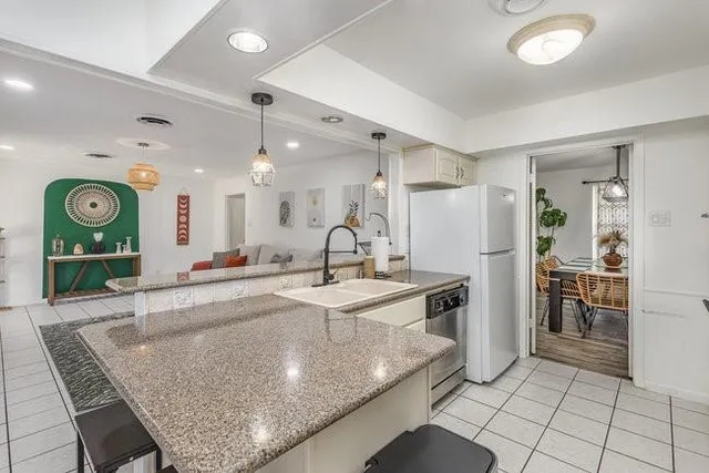 a kitchen with stainless steel appliances granite countertop a sink and a refrigerator