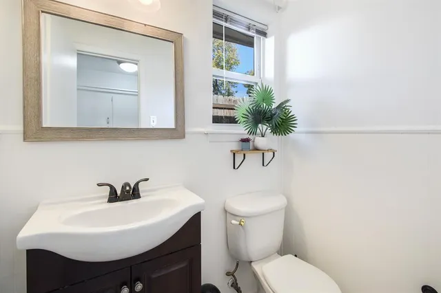 a bathroom with a toilet a sink and a mirror