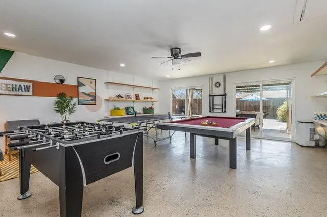 a living room with furniture pool table and a large window