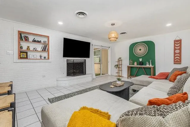 a living room with furniture a flat screen tv and a fireplace