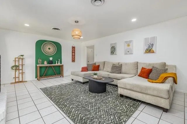 a living room with furniture a rug and a clock