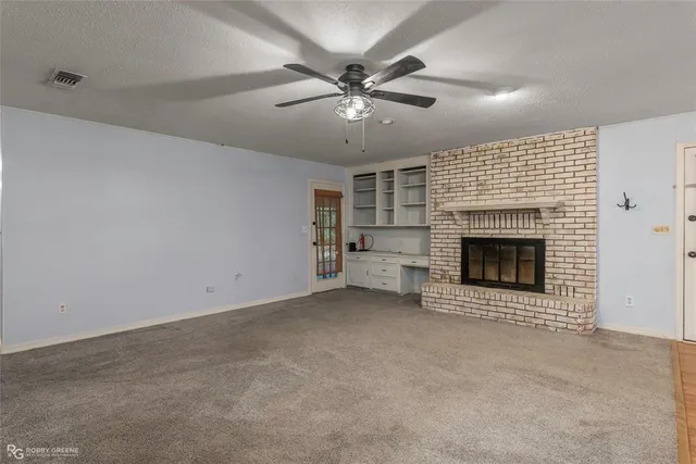 an empty room with fireplace and fan