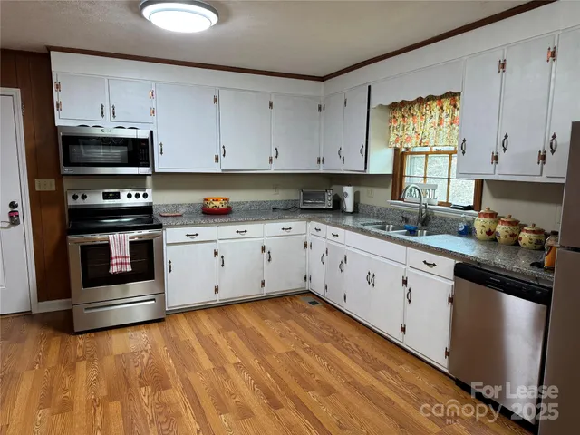 a kitchen with granite countertop white cabinets and white appliances