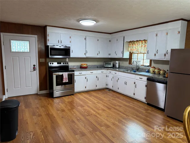 a kitchen with stainless steel appliances granite countertop a stove a sink dishwasher and a refrigerator