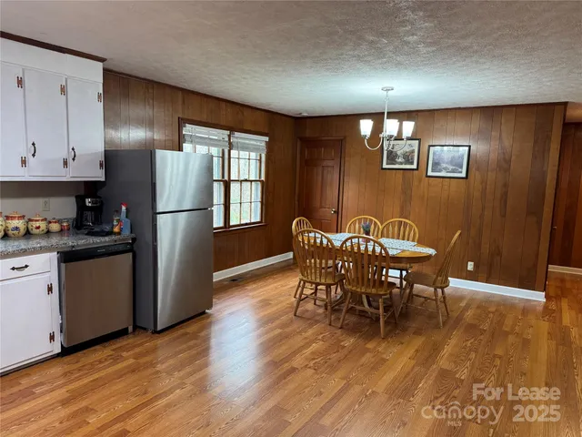 a kitchen with stainless steel appliances granite countertop a refrigerator dining table and chairs