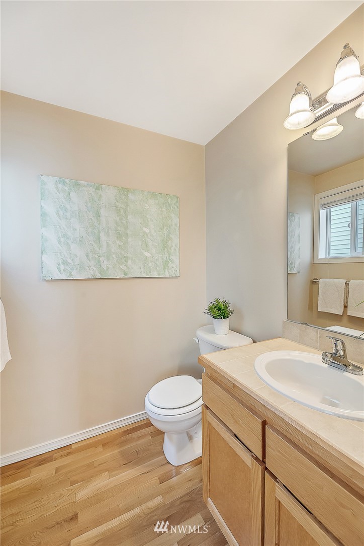 8542 B Midvale Avenue North Seattle, WA 98103 - Photo 12 of 31 a bathroom with a granite countertop toilet a sink and a mirror
