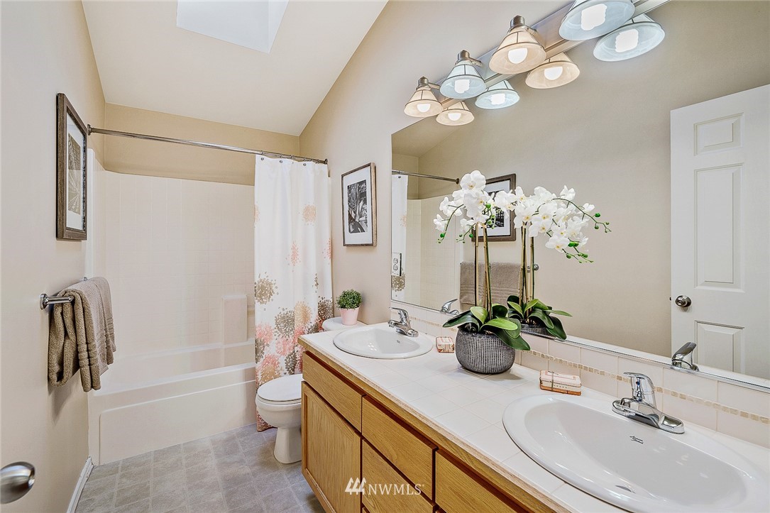 8542 B Midvale Avenue North Seattle, WA 98103 - Photo 16 of 31 a bathroom with a sink a toilet and a mirror