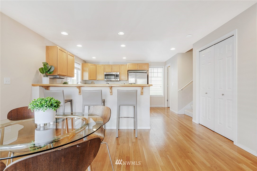 8542 B Midvale Avenue North Seattle, WA 98103 - Photo 5 of 31 a kitchen with stainless steel appliances granite countertop a refrigerator a stove a sink dishwasher and white cabinets with wooden floor