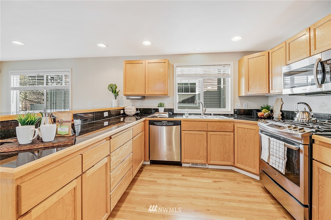 8542 B Midvale Avenue North Seattle, WA 98103 - Photo 9 of 31 a kitchen with stainless steel appliances granite countertop a stove a sink and a microwave