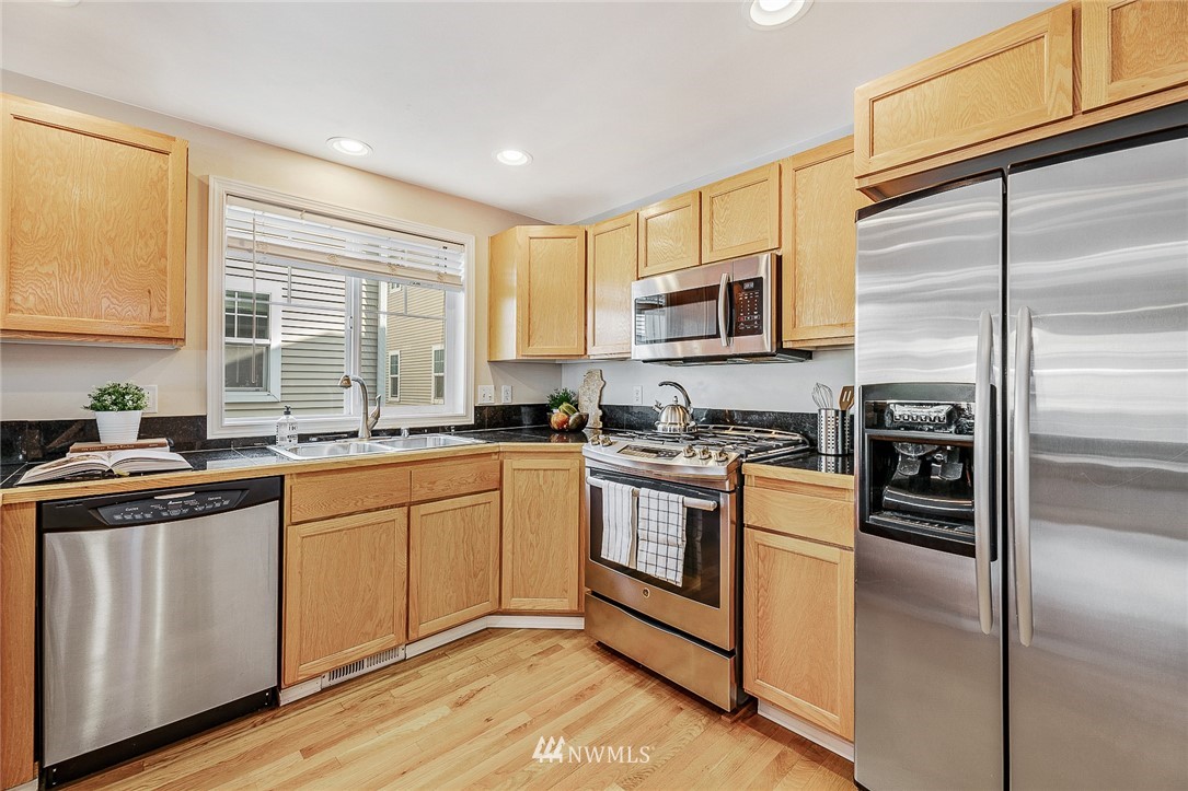 8542 B Midvale Avenue North Seattle, WA 98103 - Photo 10 of 31 a kitchen with stainless steel appliances granite countertop a stove a sink and a refrigerator