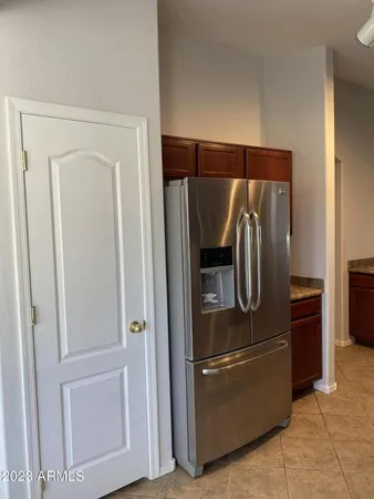 a metallic refrigerator freezer and a stove sitting inside of a kitchen