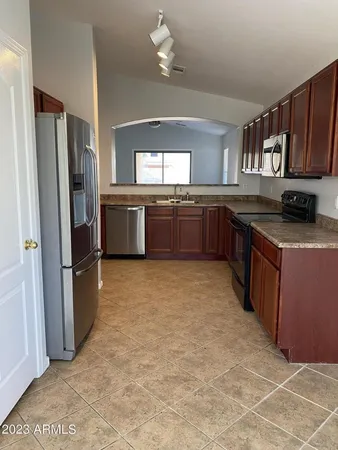 a kitchen with stainless steel appliances granite countertop a refrigerator a stove a sink a washer dryer and white cabinets