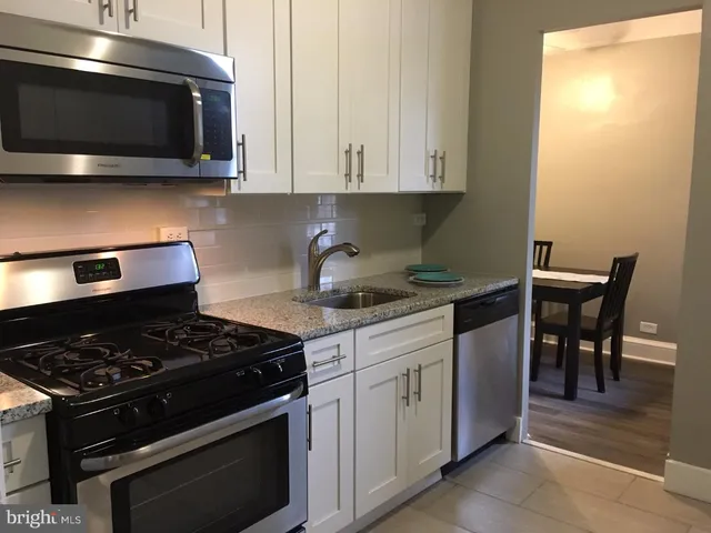 a kitchen with stainless steel appliances granite countertop a stove and a microwave