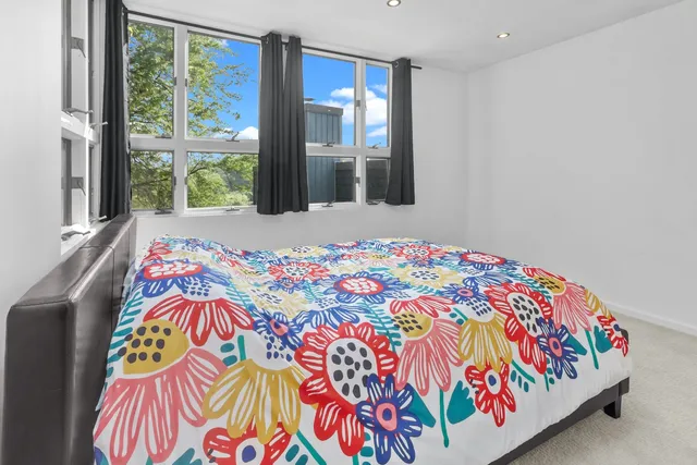 a view of a hallway with wooden floor and windows