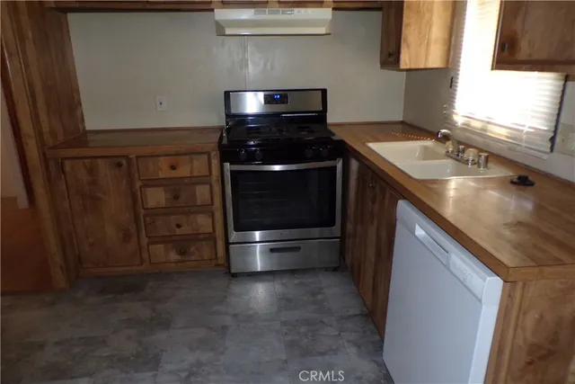 a kitchen with granite countertop a stove and a sink