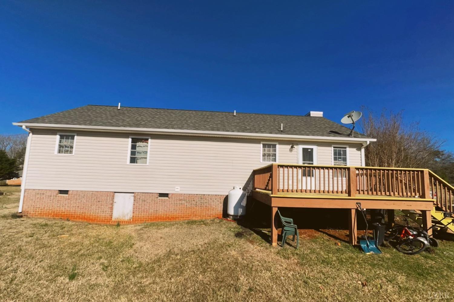 283 Country Estates Road Appomattox, VA 24522 - Photo 17 of 22 a view of a house with a wooden deck and a yard