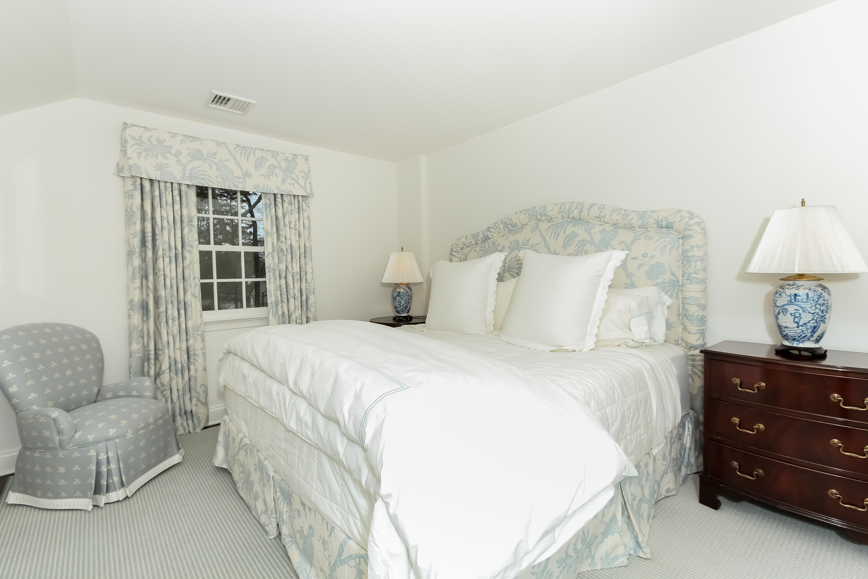 256 Brookside Road Darien, CT 06820 - Photo 31 of 66 a bedroom with a bed a couch and a window