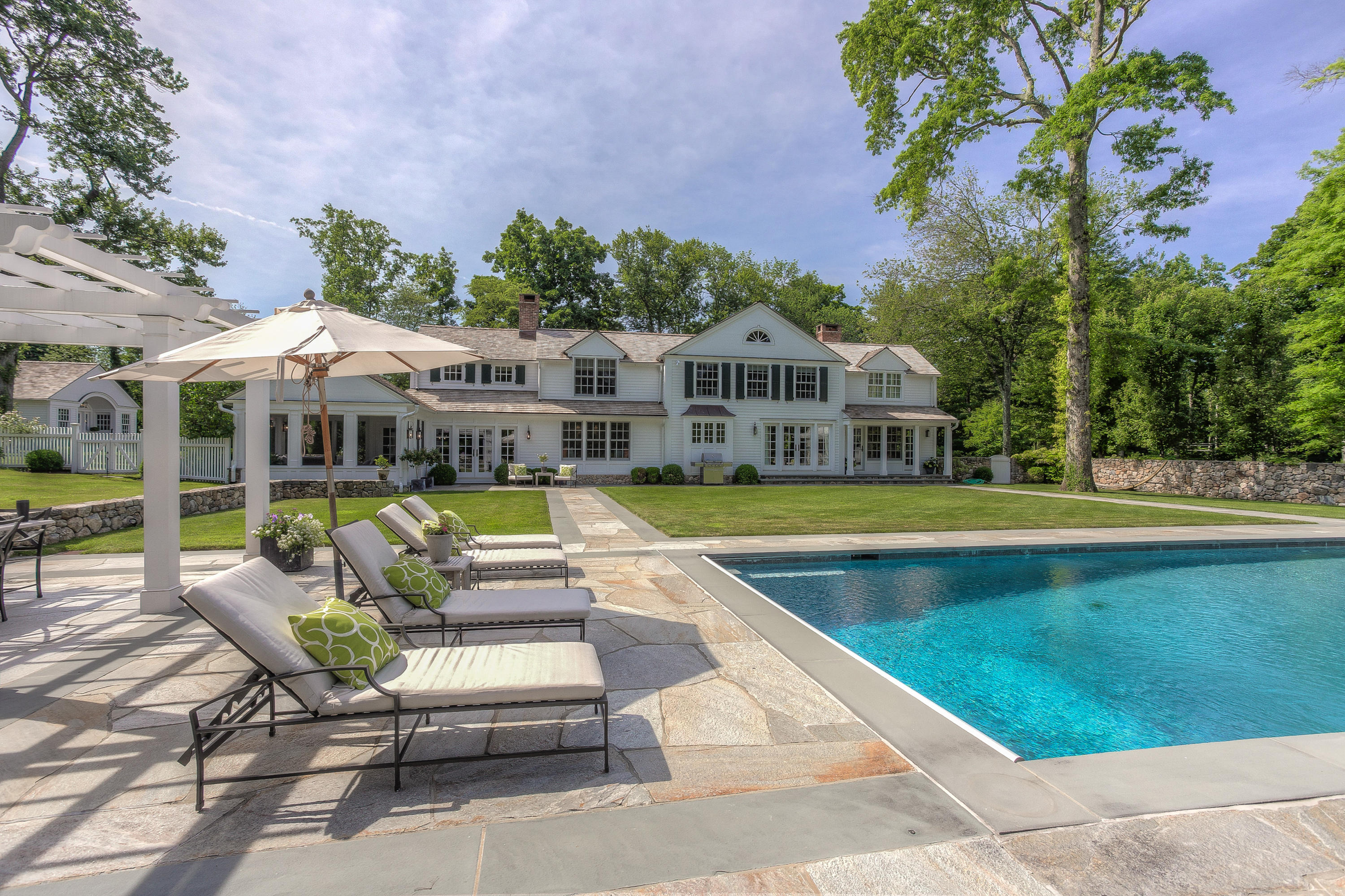 256 Brookside Road Darien, CT 06820 - Photo 34 of 66 a view of swimming pool with lounge chair in front of house