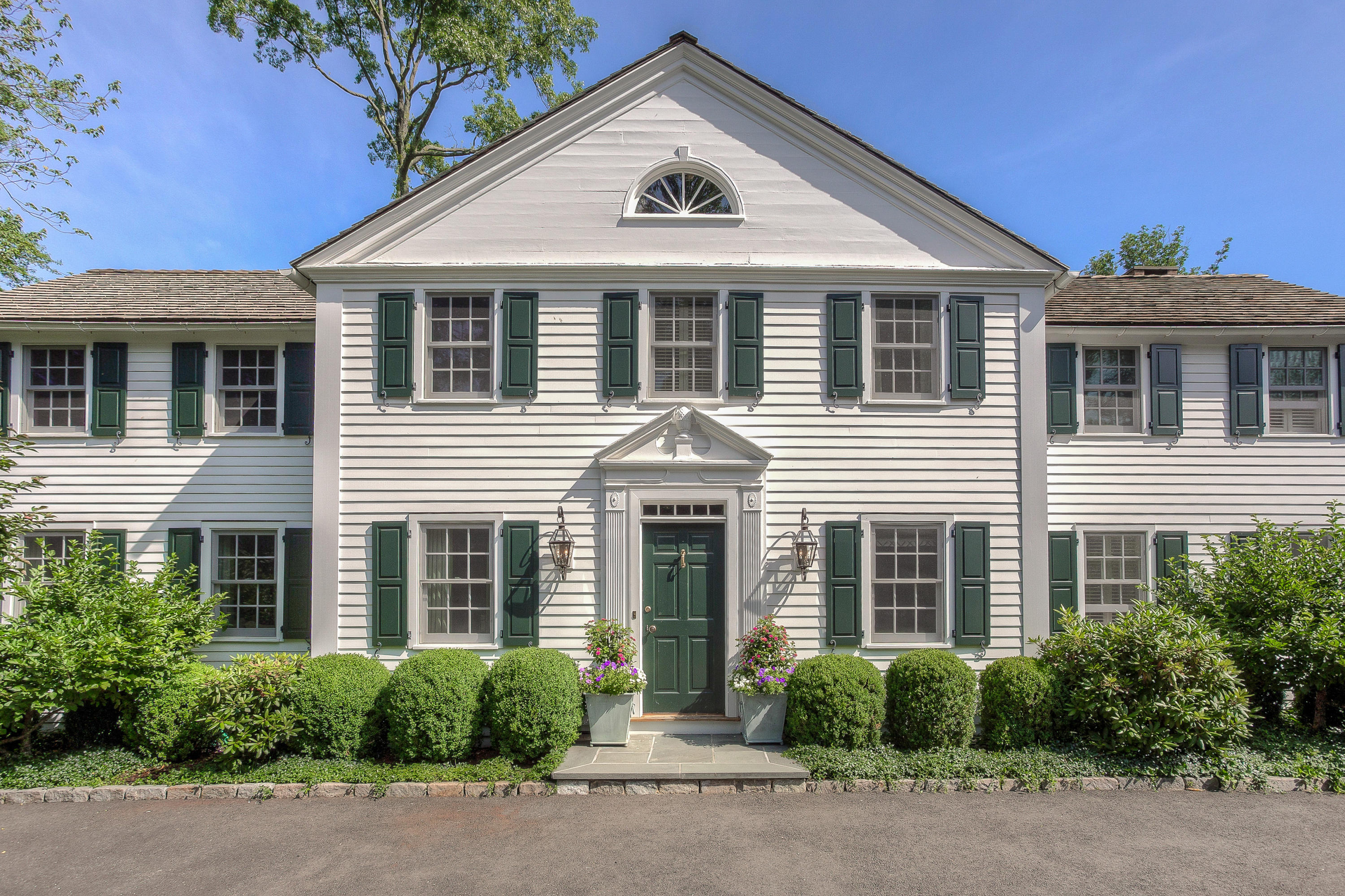 256 Brookside Road Darien, CT 06820 - Photo 8 of 66 a front view of a house with a yard and plants