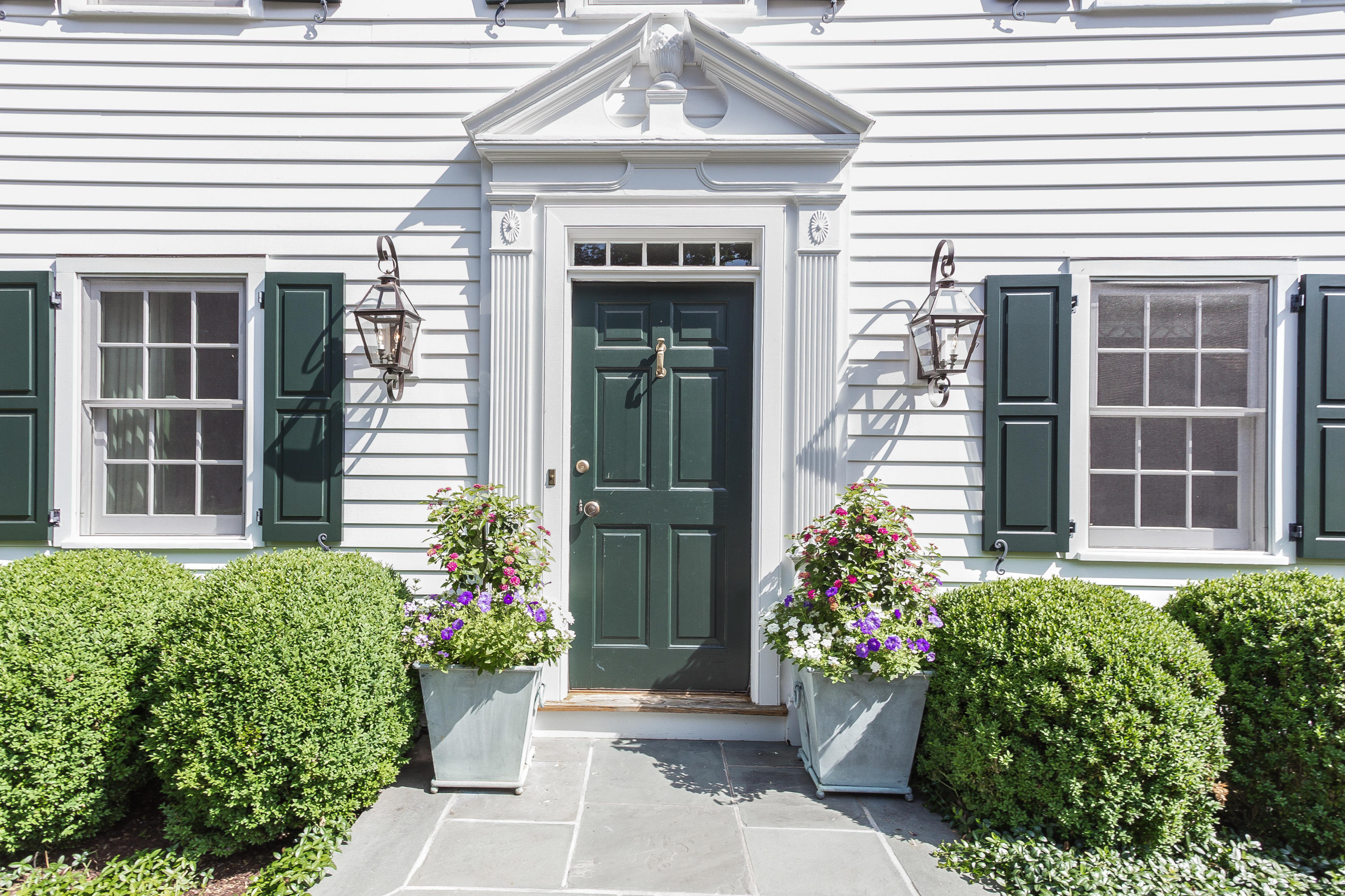 256 Brookside Road Darien, CT 06820 - Photo 9 of 66 a front view of a house with potted plants