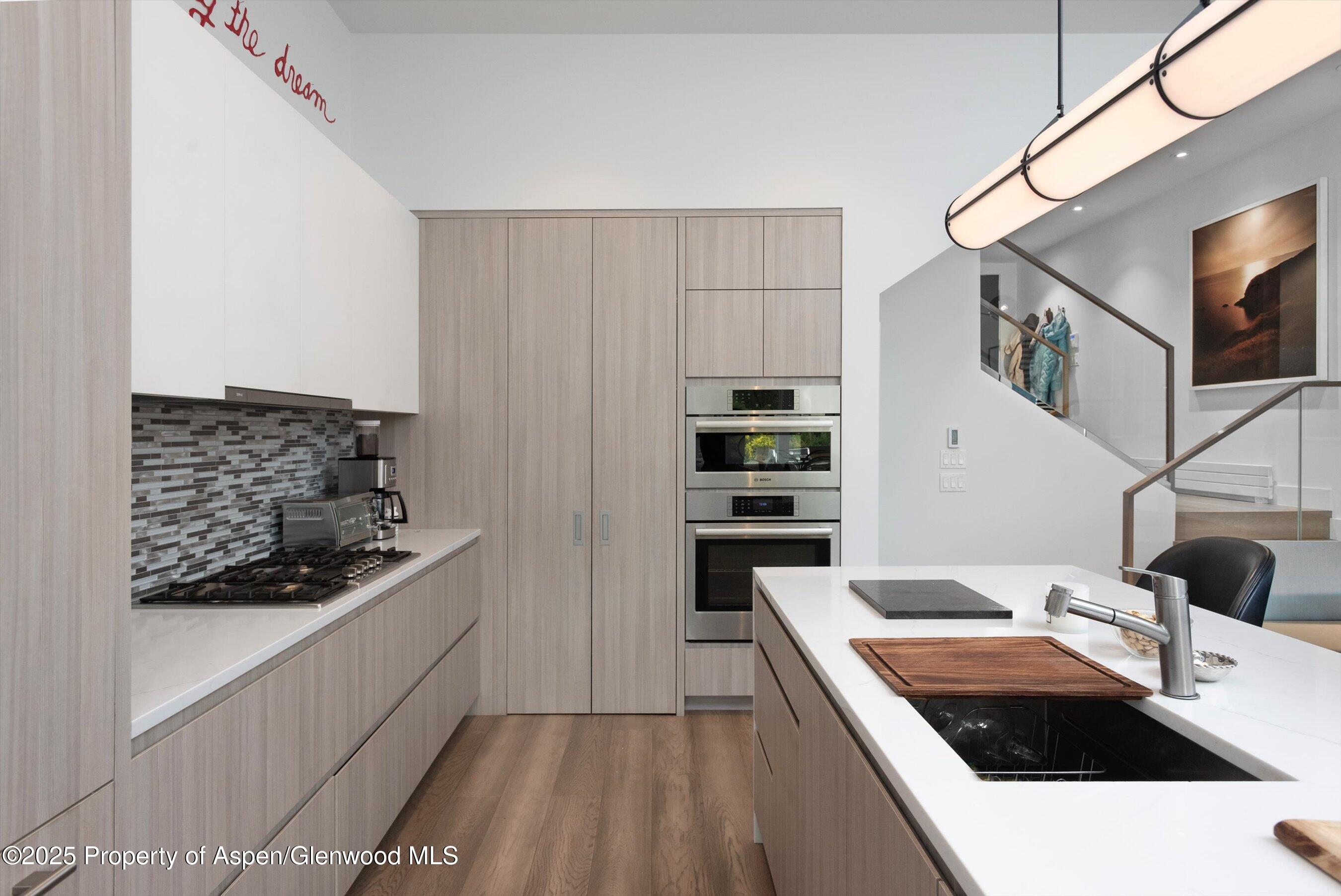 155 Lone Pine Road, Unit 8 Aspen, CO 81611 - Photo 13 of 36 a kitchen with stainless steel appliances kitchen island granite countertop a sink and cabinets