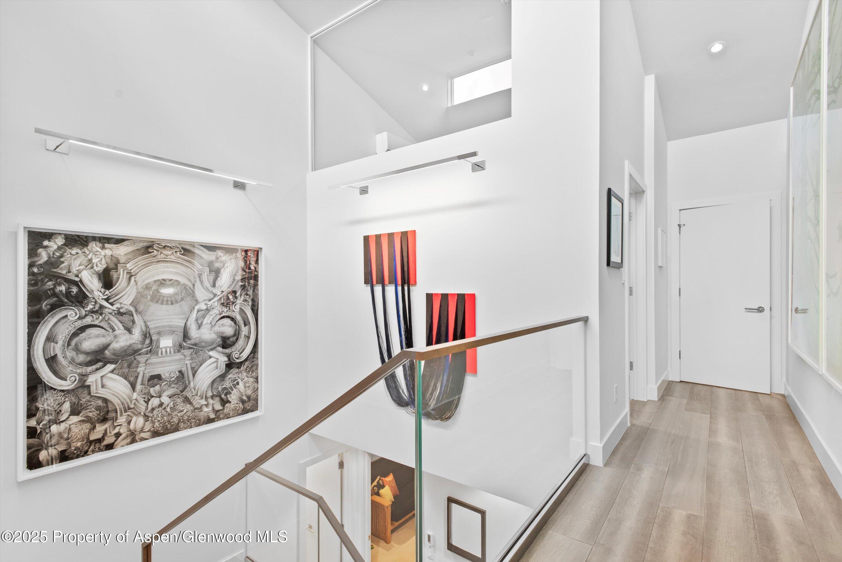 155 Lone Pine Road, Unit 8 Aspen, CO 81611 - Photo 17 of 36 a hallway with a large window and a chandelier