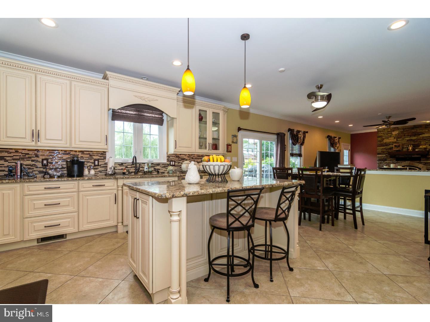 241 Shoemaker Road Huntingdon Valley, PA 19006 - Photo 7 of 25 a kitchen with stainless steel appliances kitchen island granite countertop a sink a stove a dining table and chairs with wooden floor