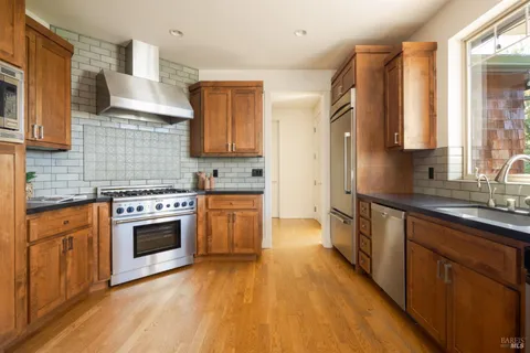 a kitchen with stainless steel appliances a stove sink and cabinets
