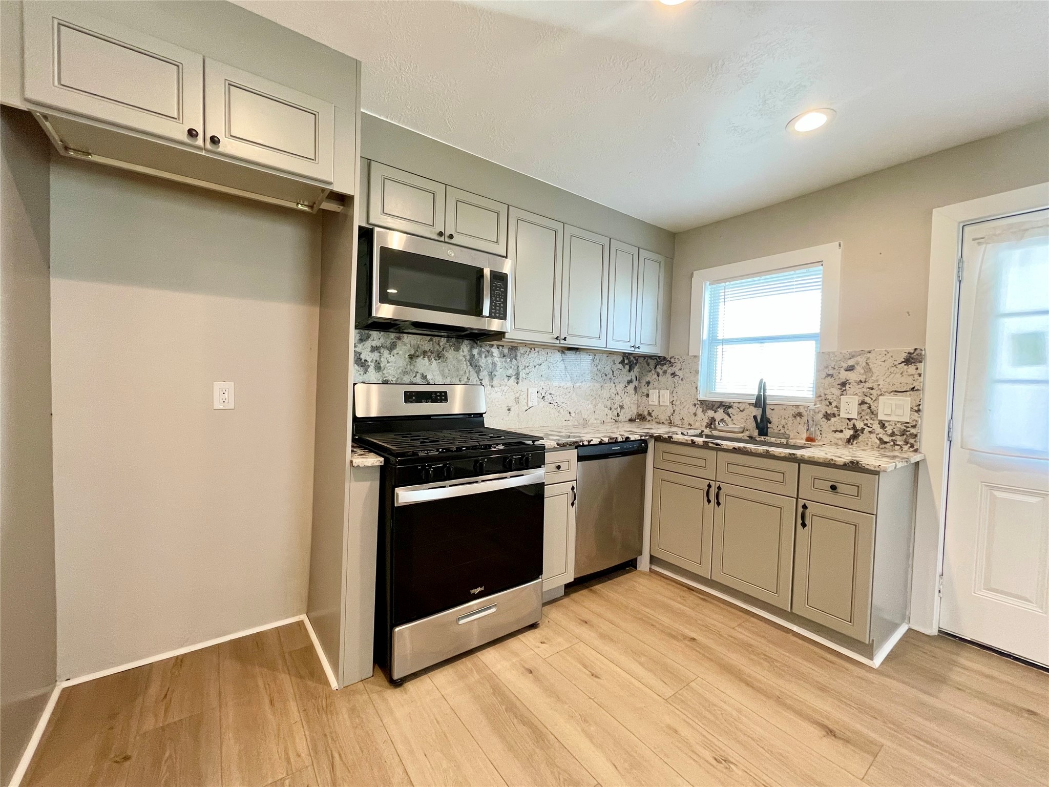 4504 Kingsbury Street Houston, TX 77021 - Photo 5 of 18 a kitchen with granite countertop a refrigerator stove and microwave