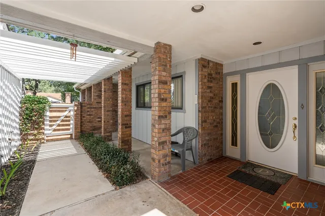 a view of a porch with a table and chairs
