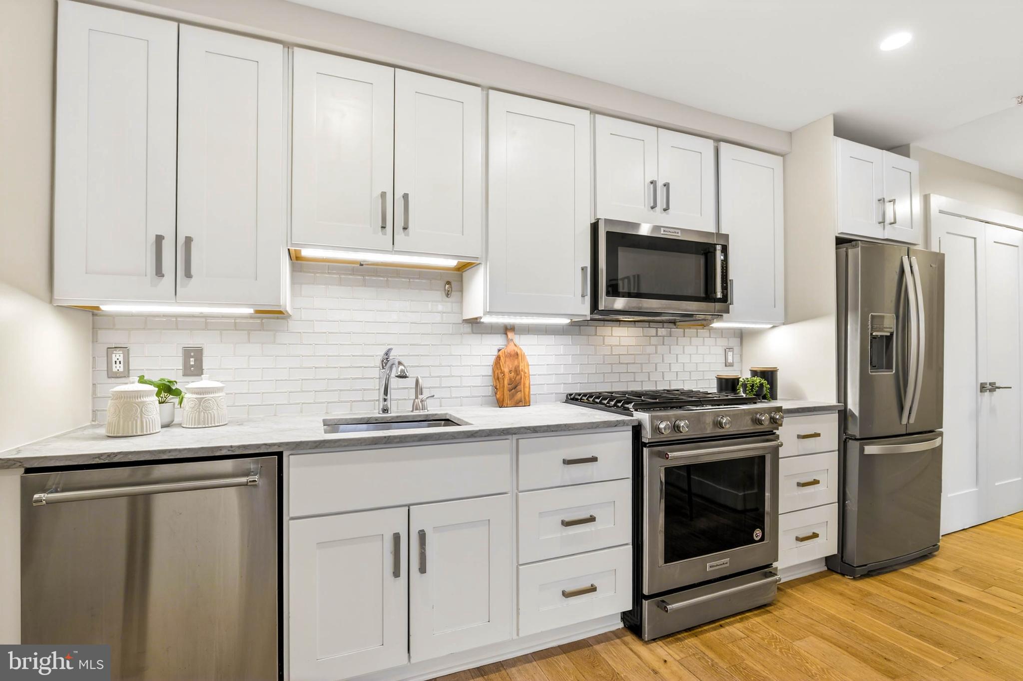 1516 K Street Southeast, Unit 2C Washington, DC 20003 - Photo 7 of 17 a kitchen with white cabinets and stainless steel appliances
