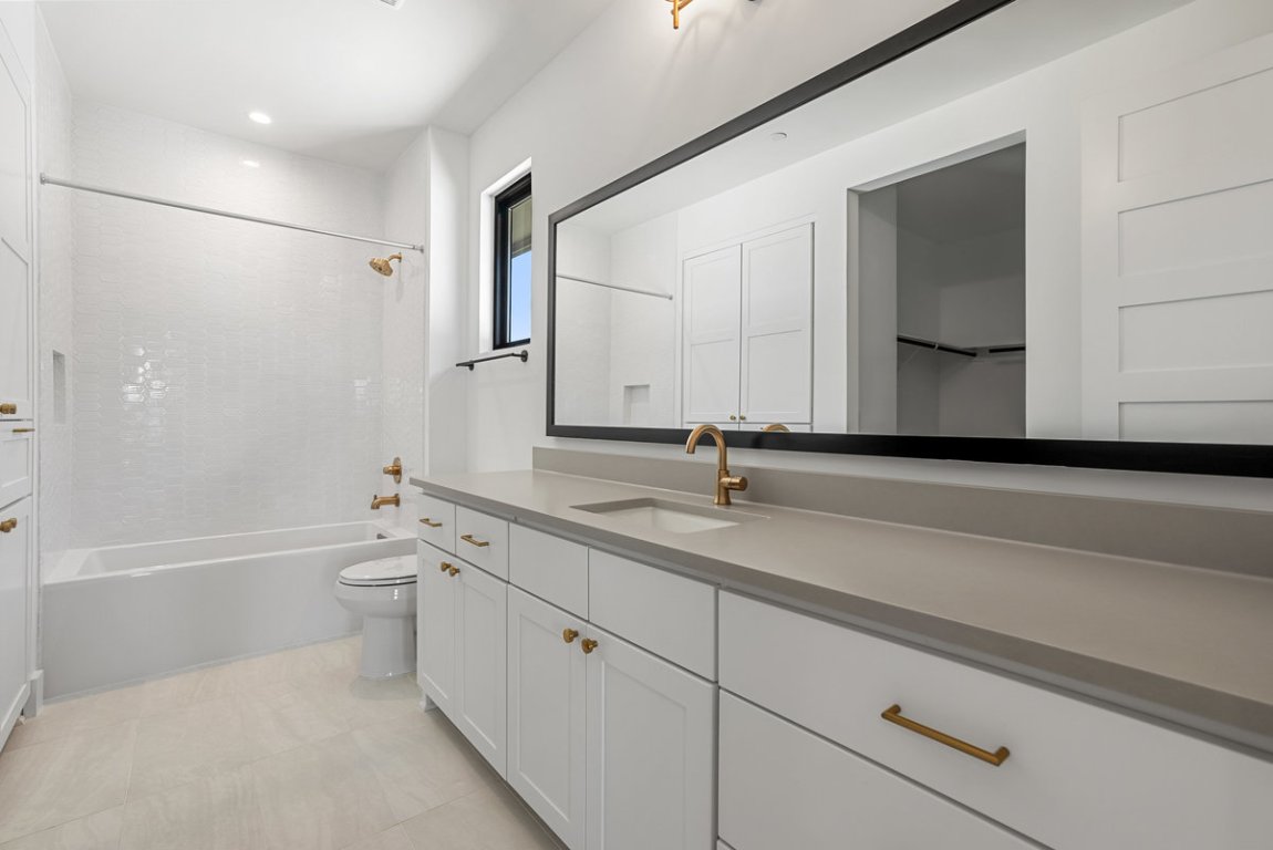 6010 Adhara Pass Austin, TX 78730 - Photo 22 of 40 a bathroom with a granite countertop sink a toilet and a bathtub