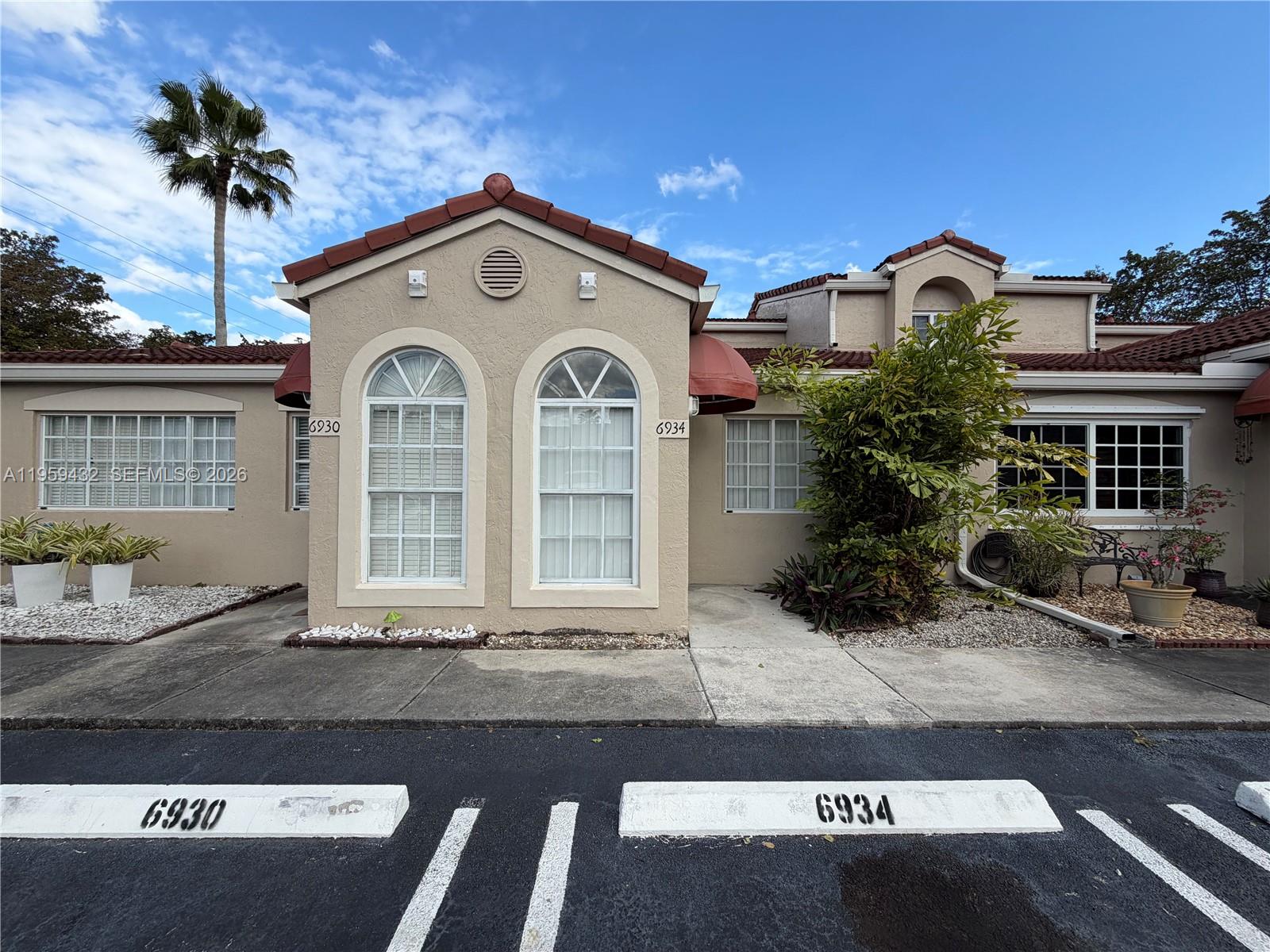 6934 Northwest 166th Terrace, Unit 1402 Miami Lakes, FL 33014 - Photo 1 of 13 a front view of a house
