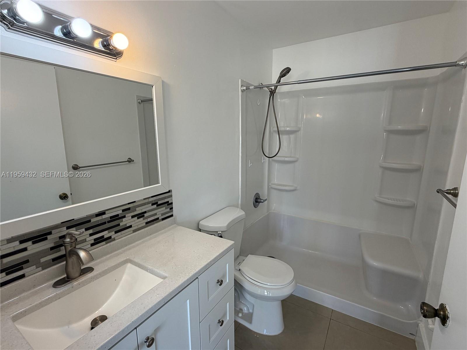 6934 Northwest 166th Terrace, Unit 1402 Miami Lakes, FL 33014 - Photo 11 of 13 a bathroom with a sink a toilet and shower