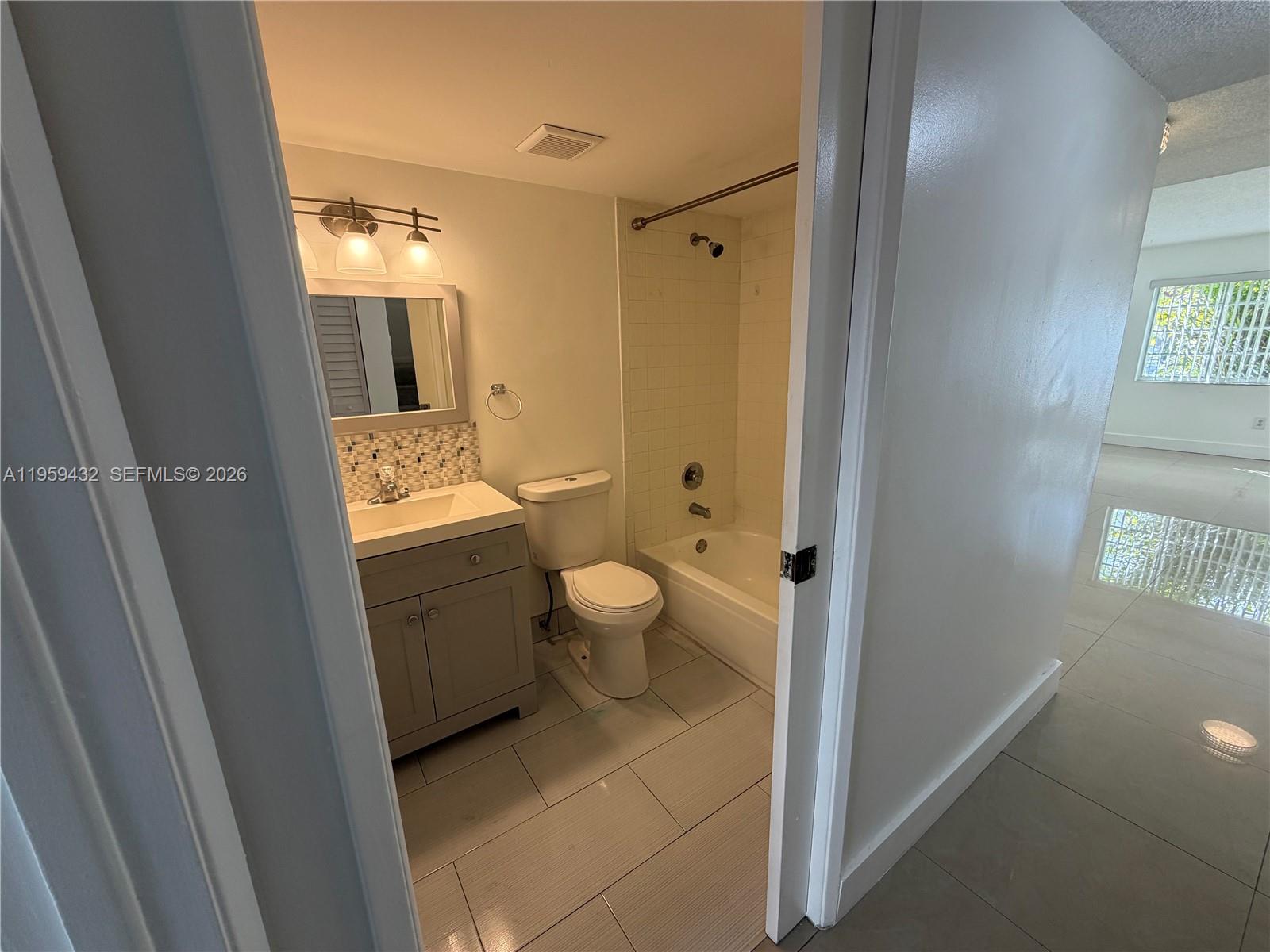 6934 Northwest 166th Terrace, Unit 1402 Miami Lakes, FL 33014 - Photo 7 of 13 a bathroom with a granite countertop sink toilet and shower