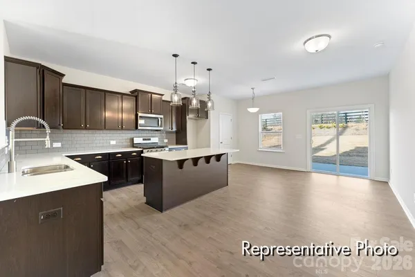 a large kitchen with kitchen island a sink stainless steel appliances and cabinets