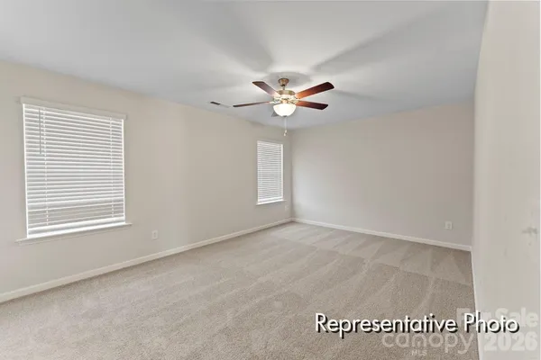 an empty room with windows and ceiling fan