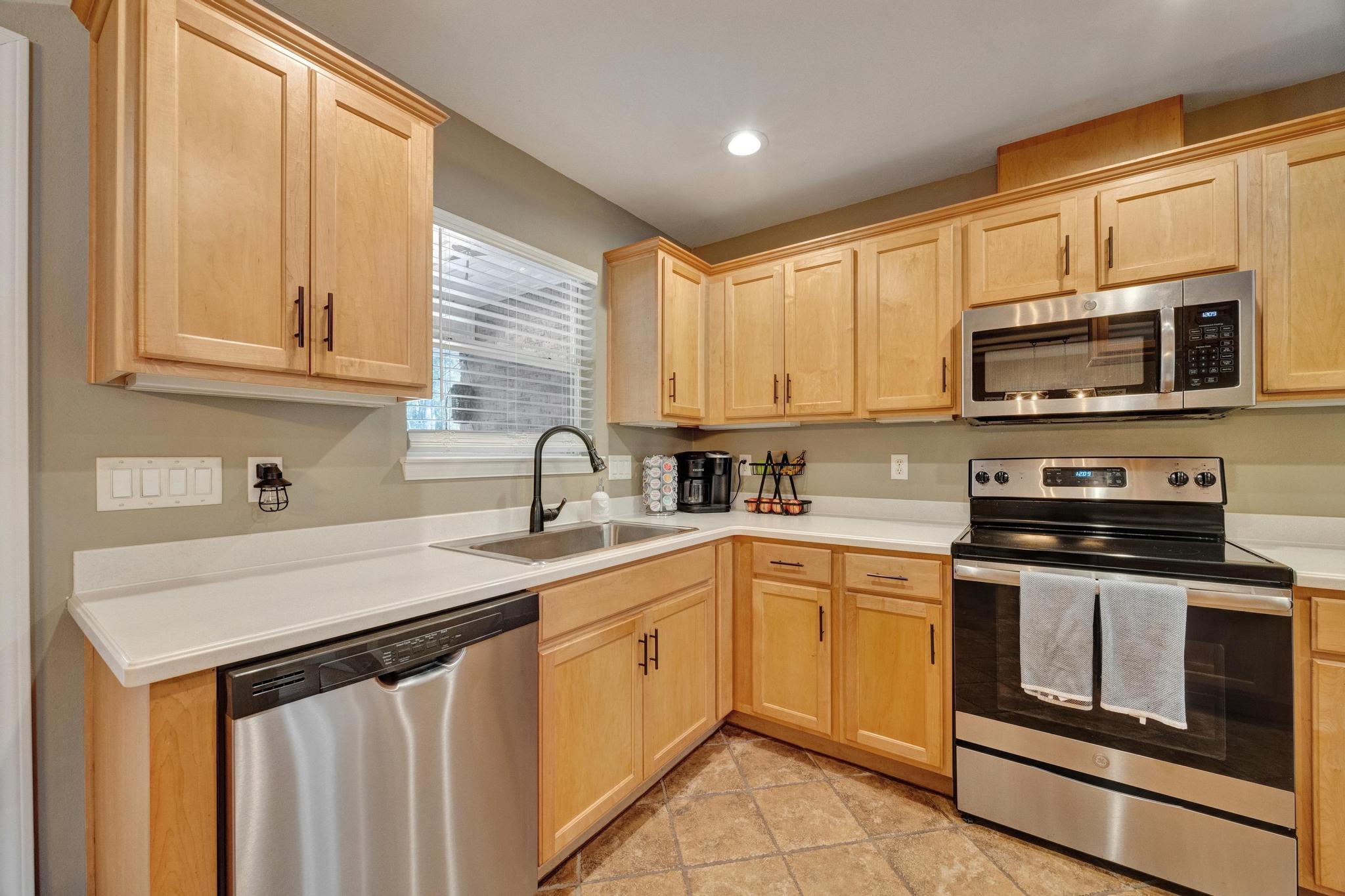 1141 Country Living Road Baker, FL 32531 - Photo 16 of 60 a kitchen with stainless steel appliances granite countertop a sink stove and microwave
