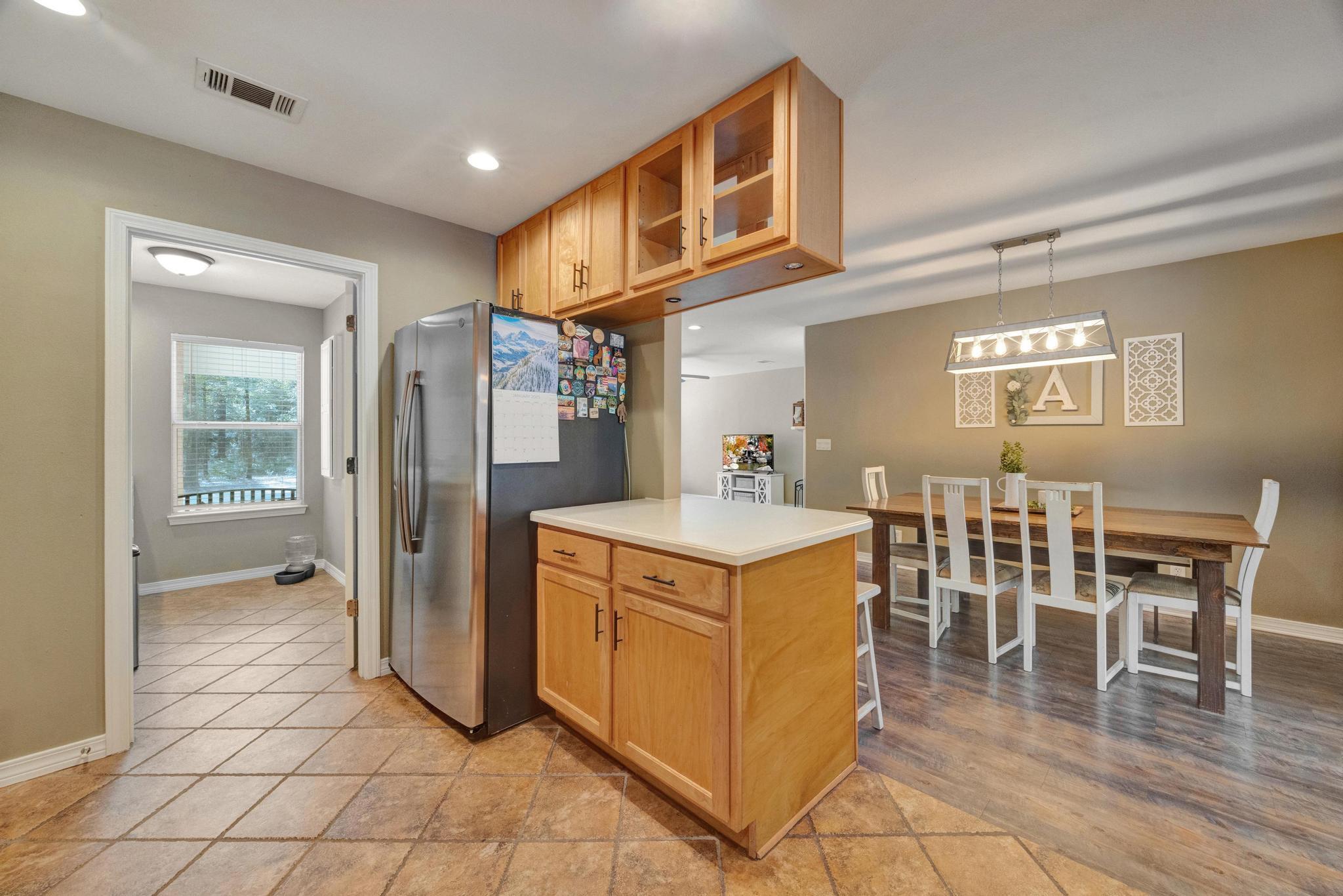 1141 Country Living Road Baker, FL 32531 - Photo 18 of 60 a kitchen with stainless steel appliances granite countertop a refrigerator a stove and a dining table with wooden floors