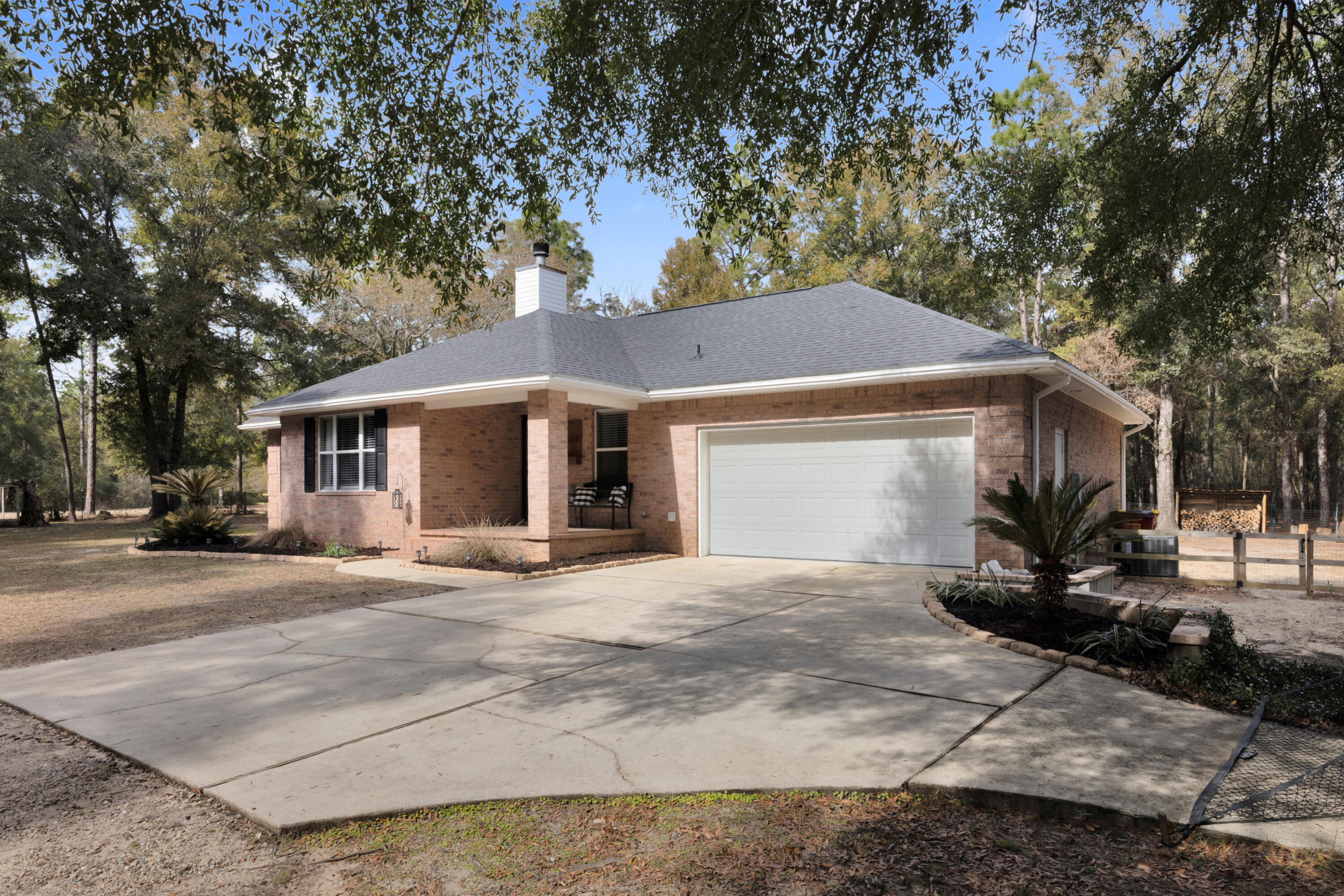 1141 Country Living Road Baker, FL 32531 - Photo 2 of 60 a front view of a house with a garden