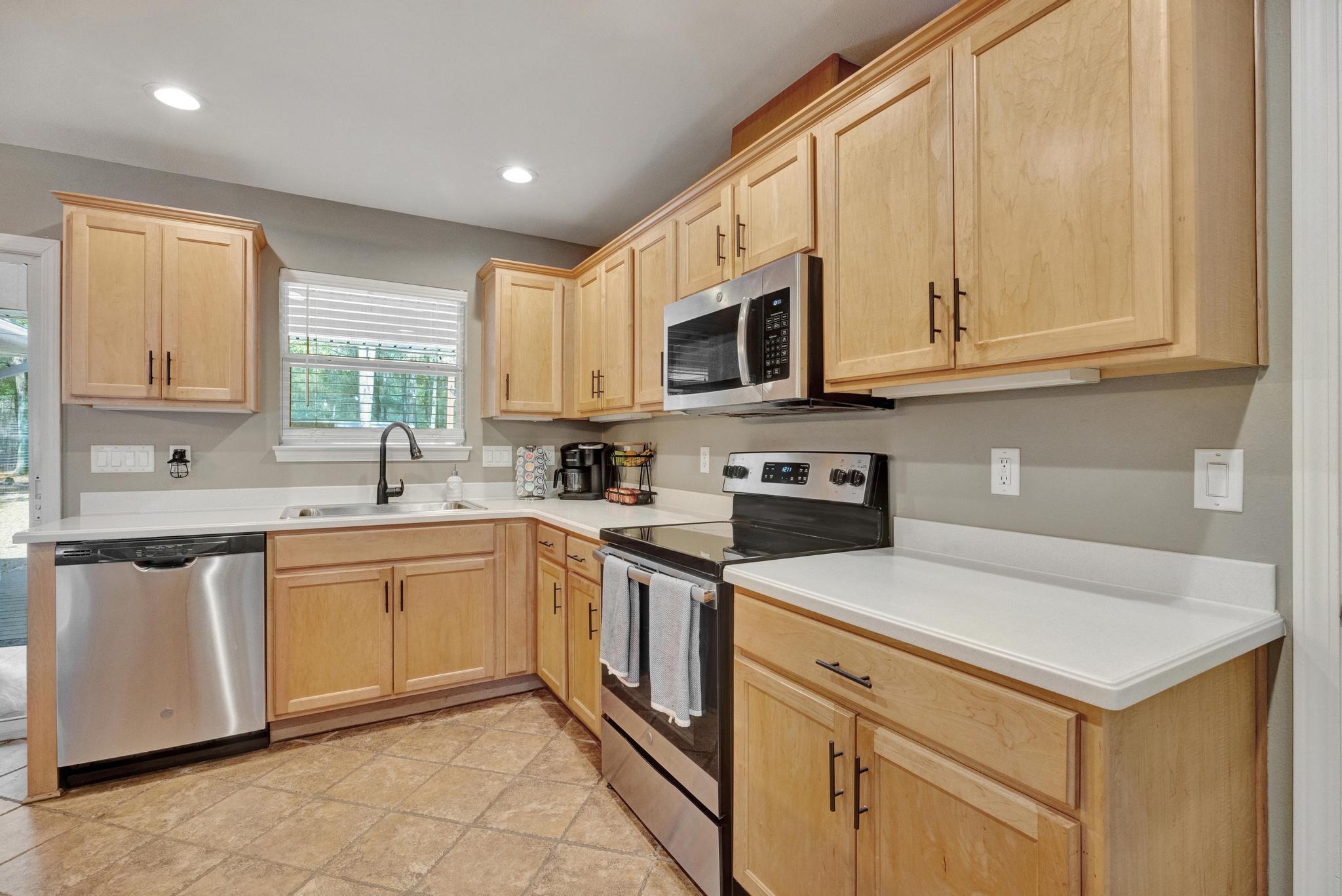 1141 Country Living Road Baker, FL 32531 - Photo 21 of 60 a kitchen with stainless steel appliances granite countertop a sink and dishwasher a stove top oven with white cabinets