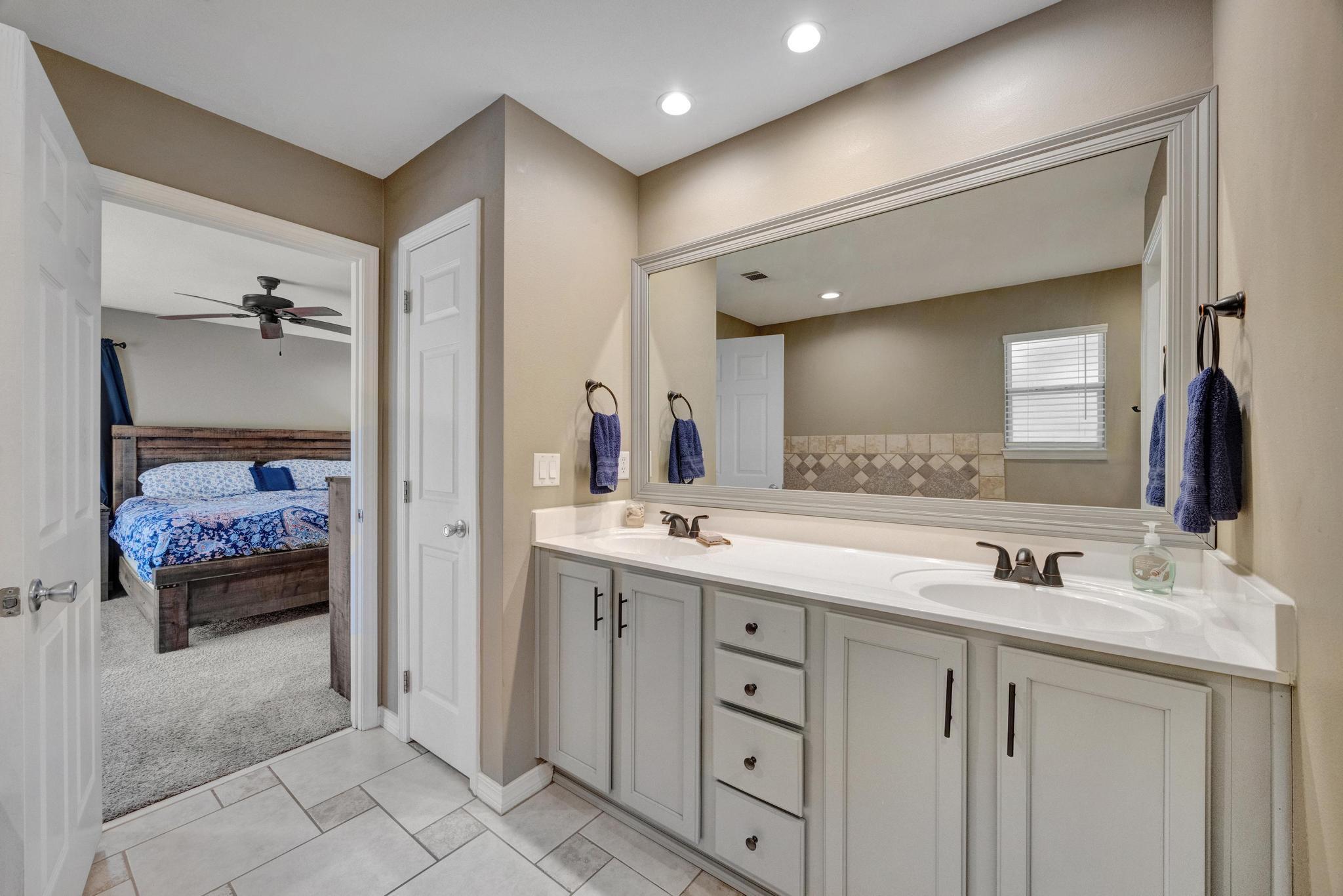1141 Country Living Road Baker, FL 32531 - Photo 28 of 60 a bathroom with a double vanity sink and a mirror