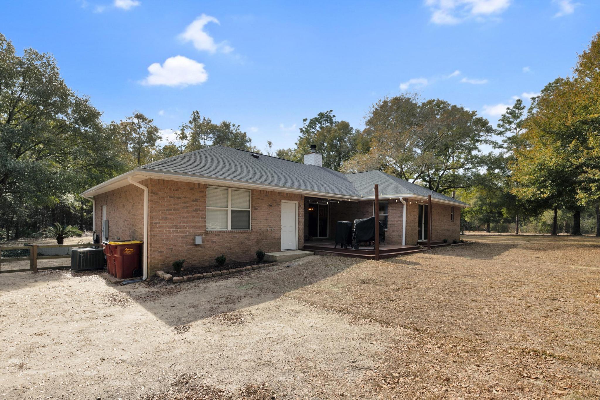 1141 Country Living Road Baker, FL 32531 - Photo 40 of 60 a view of a house with a yard and large trees