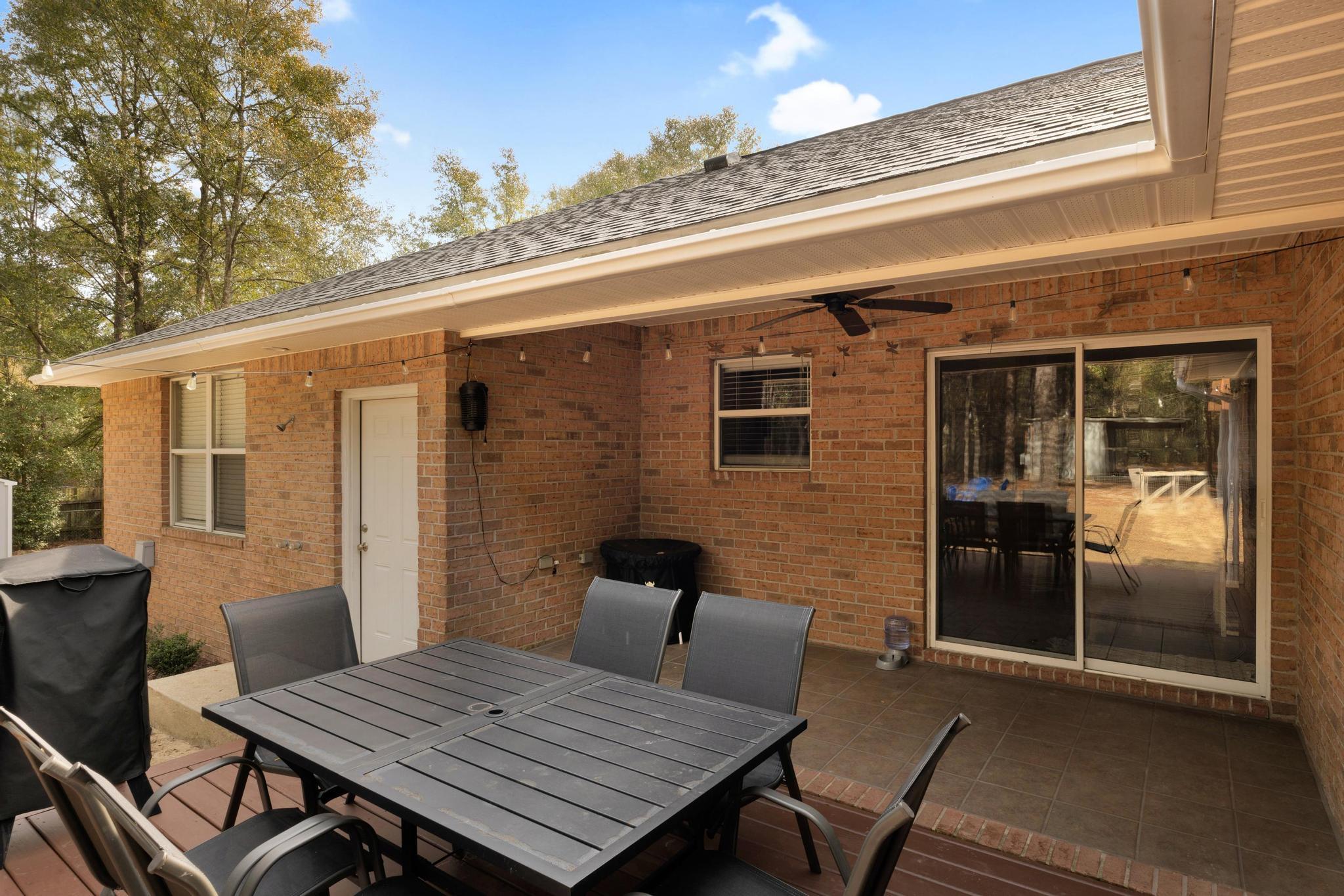 1141 Country Living Road Baker, FL 32531 - Photo 45 of 60 a view of a patio with table and chairs with wooden floor and wall