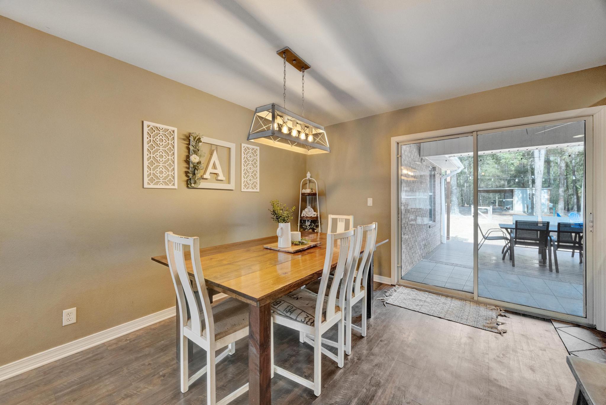 1141 Country Living Road Baker, FL 32531 - Photo 10 of 60 a view of a dining room with furniture and a floor to ceiling window