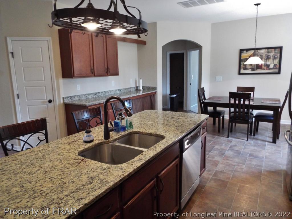 14 Citadel Street Cameron, NC 28326 - Photo 11 of 33 a kitchen with kitchen island granite countertop a sink a counter top space and cabinets
