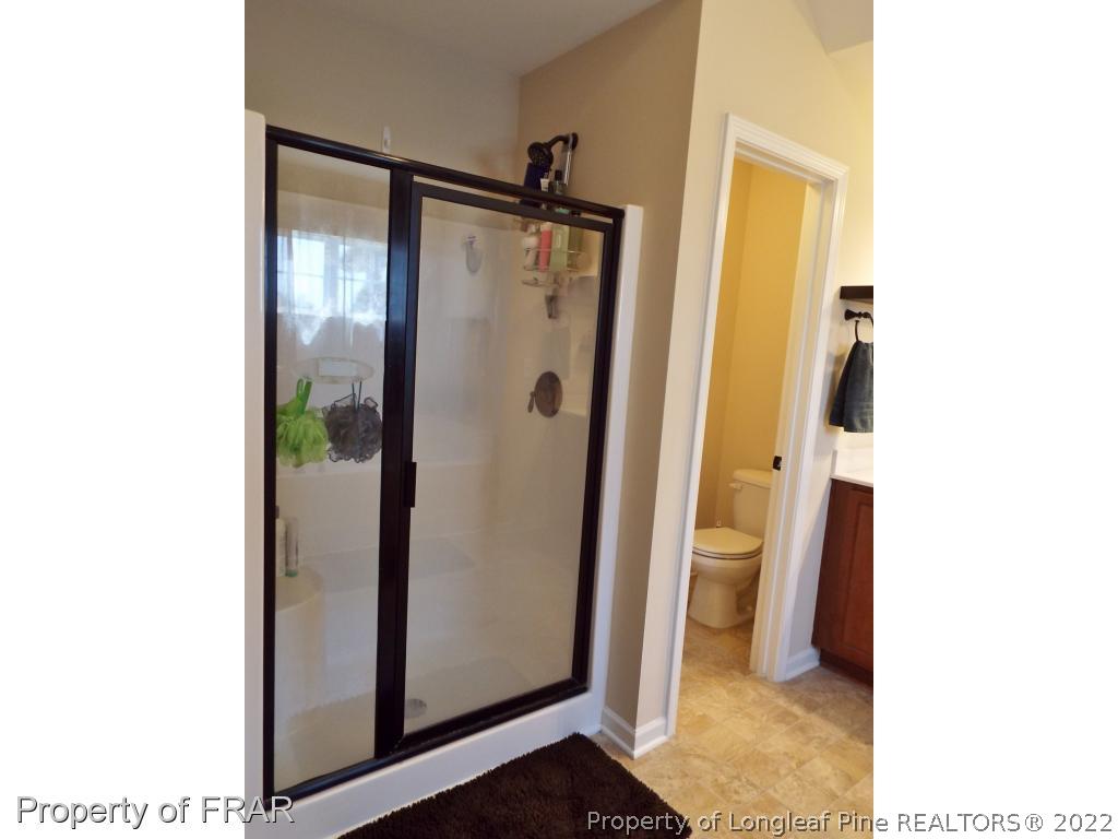 14 Citadel Street Cameron, NC 28326 - Photo 23 of 33 a bathroom with a glass shower door and a mirror