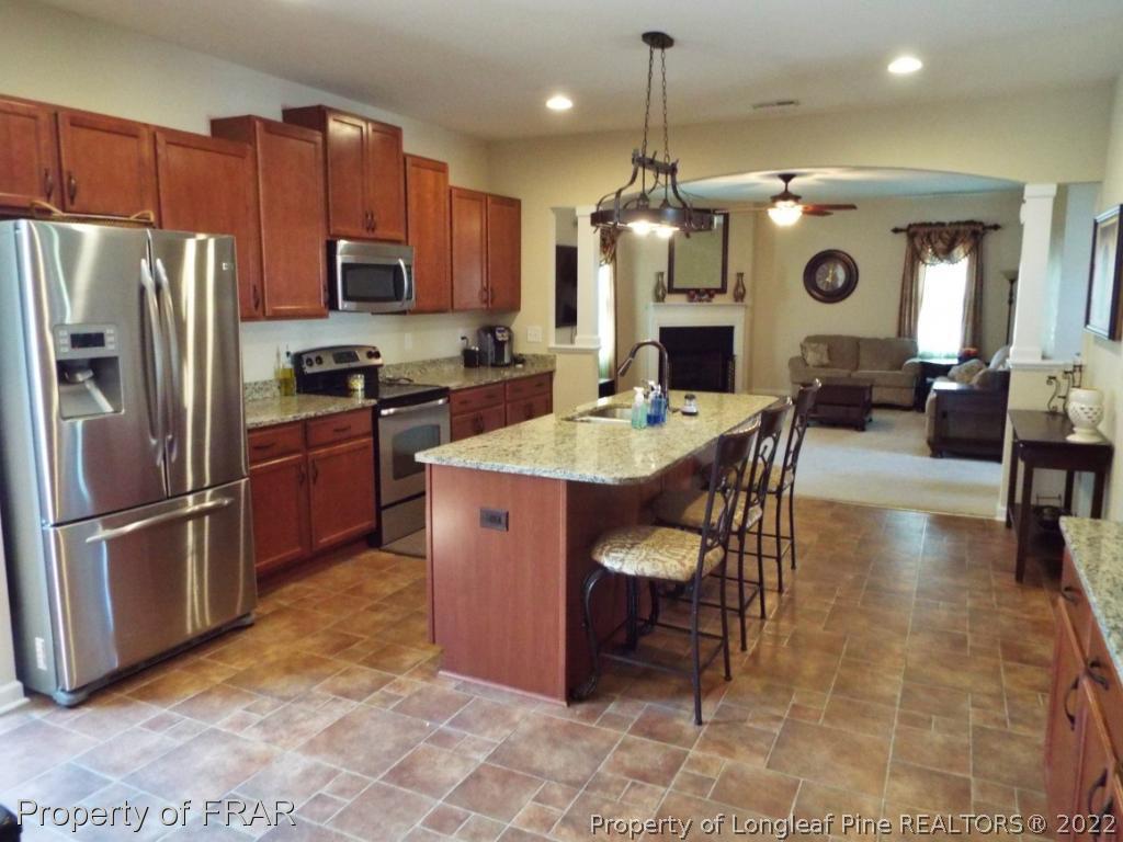 14 Citadel Street Cameron, NC 28326 - Photo 8 of 33 a kitchen with stainless steel appliances granite countertop a refrigerator a stove a sink a dining table and chairs