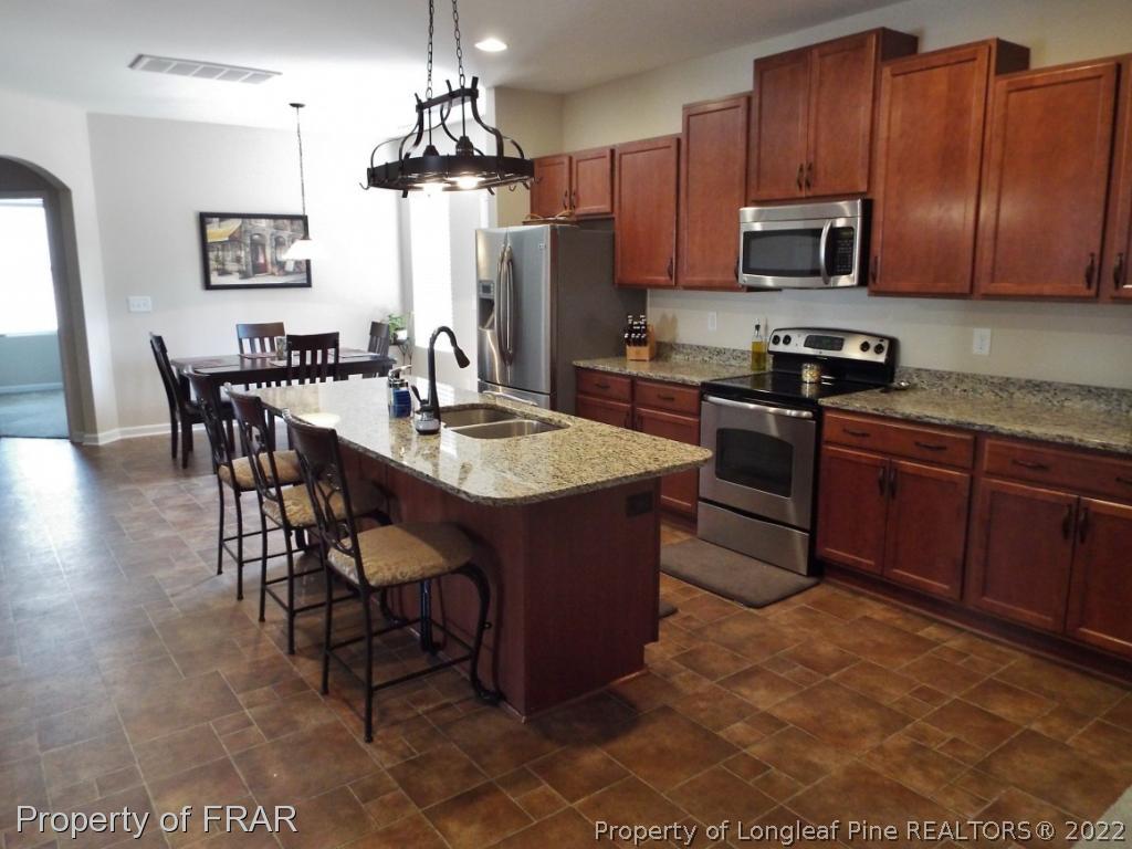 14 Citadel Street Cameron, NC 28326 - Photo 9 of 33 a kitchen with stainless steel appliances granite countertop a stove a sink dishwasher and a microwave oven with cabinets