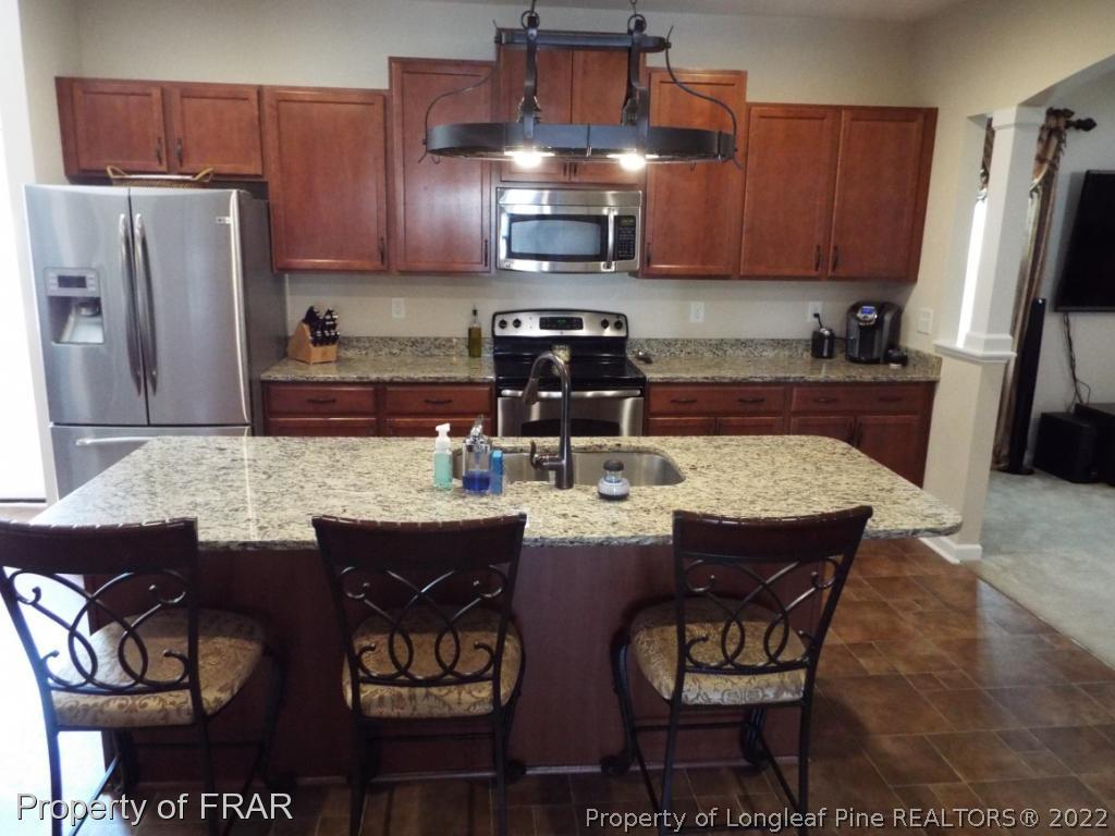 14 Citadel Street Cameron, NC 28326 - Photo 10 of 33 a kitchen with stainless steel appliances granite countertop a stove a refrigerator a sink a dining table and chairs